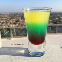 a colorful drink sitting on top of a table in front of a cityscape