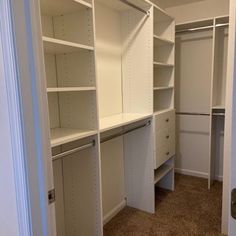 an empty walk in closet with white shelving