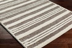 a brown and white rug on top of a wooden floor