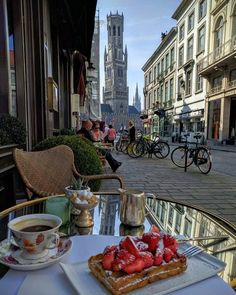 a table with some food on top of it next to a cup and saucer