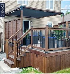 a wooden deck with railings next to a house