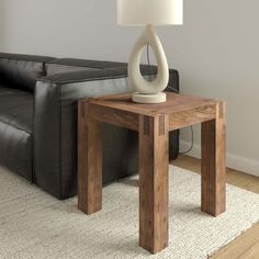 a living room with a couch, table and lamp on the floor in front of it