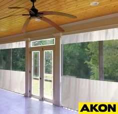 an empty room with sliding glass doors and a ceiling fan in the middle of it