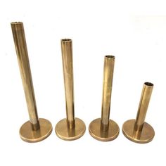 four brass colored metal poles on white background