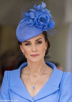 a woman wearing a blue dress and hat with a flower on it's head