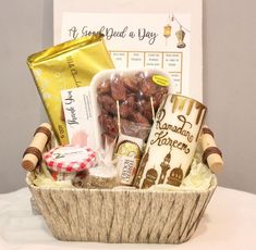 a basket filled with snacks and candy on top of a white tablecloth covered table