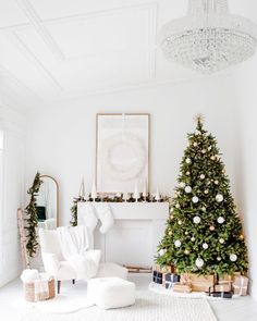 a living room with a christmas tree in the corner and decorations on the fireplace mantel