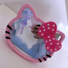 a pink heart shaped mirror sitting on top of a white counter next to a wall