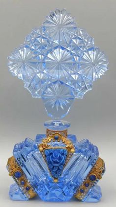 a blue glass vase with gold trimmings and an elaborate design on top of it