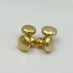 two gold colored knobs on a white background