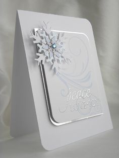 a white card with a snowflake on it and the word peace is written in silver