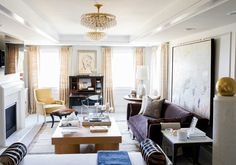 a living room filled with furniture and a fire place in front of a tv mounted on a wall