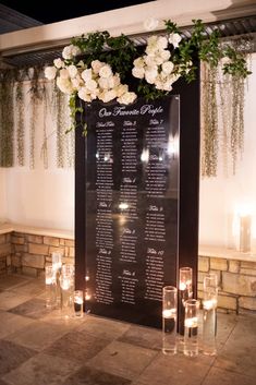 a table with candles and flowers on it in front of a sign that says guest information