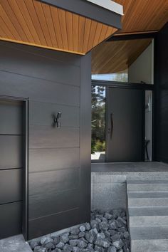 the entrance to a modern home with stone steps