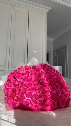 a large bouquet of pink roses sitting on top of a table