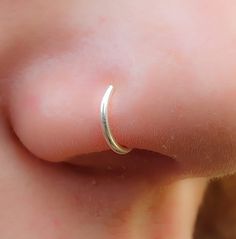 a close up of a person's nose with a ring on it