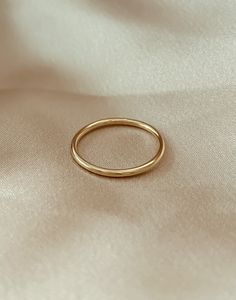 a gold wedding band on a white cloth