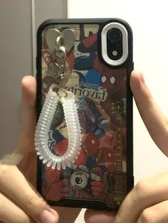 someone is holding up their phone case with a keychain attached to it