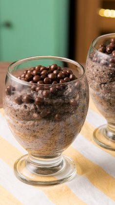 two glasses filled with food sitting on top of a table