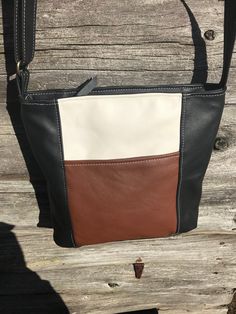 "Large Emily style in multicolor leather - caramel, black, and cream. This is a slightly larger version of our original Emily style bag. It has an adjustable strap, so you can wear it crossbody or shorten it for over-the-shoulder carry. It has two outside pockets, one open and one with a zipper. The main compartment has a secure zipper closure. The interior is fully lined with lightweight and very durable upholstery material, with three slide-in sectional pockets on one side and a zippered pocke Cream Leather Shoulder Bag With Leather Trim, Cream Shoulder Bag With Leather Lining For Daily Use, Cream Leather Shoulder Bag With Leather Lining, Leather Checkbook Cover, Expensive Bag, Checkbook Cover, Black Leather Purse, Slide In, Black And Cream