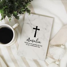 a cup of coffee next to a book with a cross on it