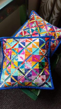 two colorful pillows sitting on top of each other