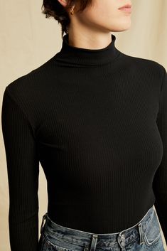 Long sleeve turtleneck with a fitted silhouette, made in our signature ultra-soft Paris Rib. This versatile top is perfect to tuck into jeans or wear as a first layer. Model is 5'10" and wears size Small. Black Turtleneck Top With Ribbed Neckline, Stretch Black Turtleneck With Ribbed Collar, Black Stretch Turtleneck With Ribbed Collar, Black Cashmere Turtleneck With Ribbed Collar, Solid Fitted Turtleneck T-shirt, Ribbed Turtleneck, Long Sleeve Turtleneck, French Girl, Ribbed Fabric