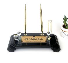 a black and gold desk organizer with two brass scissors