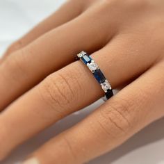 a woman's hand with a blue and white diamond ring