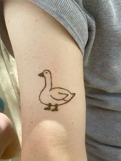 a woman with a tattoo on her arm has a duck drawn on the side of her arm