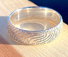 a silver ring sitting on top of a wooden table