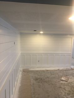 an empty room with white paneling on the walls and carpeted floor in front of it