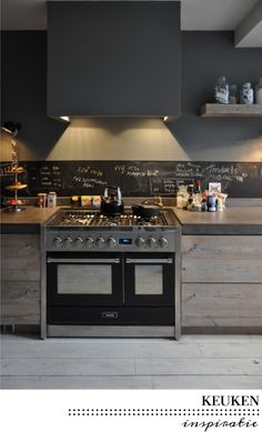 a kitchen with an oven, stove and chalkboard on the wall above it's counter