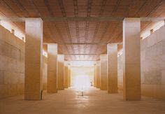 an empty building with columns and light coming through