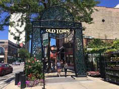 two people standing in front of an old town entrance