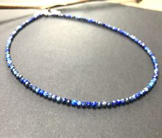 A minimalist necklace made with rich blue beads of genuine lapis lazuli. These AAA quality stones measure 2mm in diameter, and they are round with multifaceted cuts that give them a little extra shimmer in the light. There is a small silver bead at each end, and this connects with a sterling silver lobster claw clasp in the back. Available in a variety of lengths, and comes packaged in a small gift box for you. Ships in 1 business day, via USPS ground advantage. Lapis Lazuli Necklace With Faceted Beads, Blue Lapis Lazuli Crystal Necklaces With Faceted Beads, Round Lapis Lazuli Necklace With Faceted Beads, Blue Lapis Lazuli Crystal Necklace With Faceted Beads, Blue Minimalist Jewelry With Faceted Beads, Blue Rondelle Crystal Necklace For Gift, Blue Rondelle Crystal Necklace Gift, Blue Faceted Round Bead Crystal Necklace, Blue Faceted Crystal Necklace With Round Beads