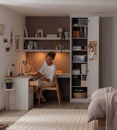 a woman sitting at a desk in front of a book shelf