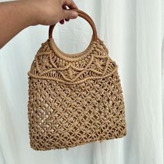 Elevate your style with our handmade crochet tote bag, crafted from durable nylon rope. Measuring 40 cm in length, 1 cm in width, and 33 cm in height, this elegant handbag is perfect for any occasion. Its intricate crochet pattern, paired with a round wooden handle, adds a natural charm to your outfit. Whether for casual outings, beach days, or as a statement piece, this tote bag combines functionality with artisanal beauty. Please note, shipping time is approximately 15 to 21 days. Beige Summer Crochet Bag With Top Carry Handle, Summer Beige Crochet Bag With Top Carry Handle, Woven Crochet Top Handle Bag For Daily Use, Trendy Natural Crochet Bag With Top Carry Handle, Beige Macrame Straw Bag For Travel, Eco-friendly Crochet Satchel Bag With Top Handle, Beige Macrame Crochet Shoulder Bag, Beige Crochet Shoulder Bag With Macrame, Beige Crochet Macrame Shoulder Bag