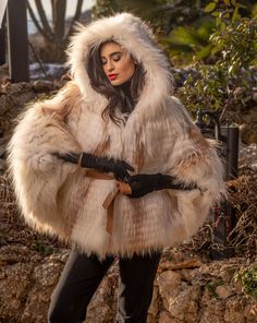 The most impressive Fox cape in a special white with gold details color. With a great hood, 7/8 sleeves, and a leather belt on the waist that points out your body lines. With a soft and fluffy texture, that characterizes a winter outerwear of high quality and impeccable taste. A magnificent piece for dynamic women with aesthetic, like you! Two tone fox fur cape In natural white with gold details color Fur cape with eye hook closures Front closure Concealed side pockets Long hair fur pelts 7/8 sl Cape With Hood, Outerwear Women Winter, Fur Cape, Luxury Gifts For Her, Fur Clothing, Mink Fur Coat, Winter Outerwear, Fox Fur Coat, Cold Weather Fashion