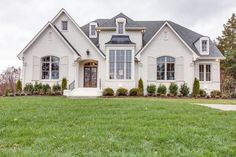 a large white house sitting on top of a lush green field