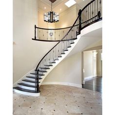 an elegant staircase with chandelier and tiled floor