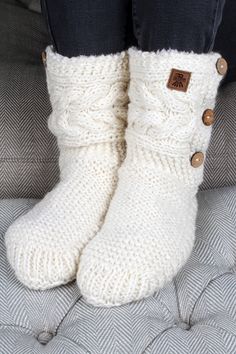 someone wearing white knitted boots with buttons