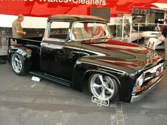 an old black pickup truck is on display