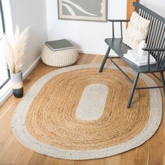 a room with a chair, rug and pictures on the wall in front of it