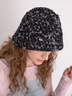 a woman wearing a black hat while looking at her cell phone