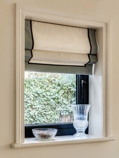 a window sill with a bowl and vase on it