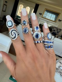 a woman's hand with five different rings on it