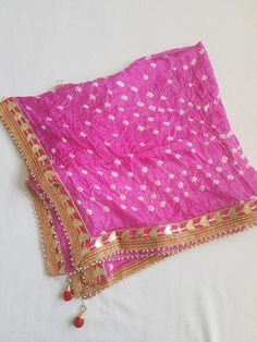 Ethnic Beautiful Bandhej Rajasthani silk Dupatta with heavy gotawork , latkans and pearls to be paired with ethnic Kurtas or white kurtas which gives a unique look which is a must buy.These dupattas have all four side pearl border for a attractive look. Dupatta length 2.25 metre Kundan Choli With Gota Work For Eid, Gold Saree With Gota Work For Puja, Pink Chandbali Shaped Dupatta In Chinon, Diwali Chanderi Choli With Gota Work, Bollywood Pink Kundan Dupatta, Festive Pink Kundan Dupatta, Semi-stitched Traditional Wear With Pallu For Festivals, Katan Silk Traditional Wear With Gota Work For Eid, Gold Katan Silk Traditional Wear With Gota Work