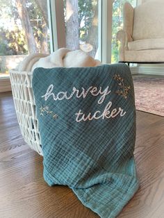 a blue blanket sitting on top of a wooden floor next to a basket filled with towels