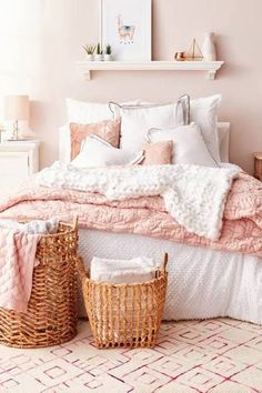 a bedroom with pink walls, white bedding and wicker baskets on the floor